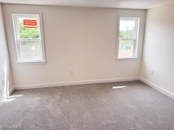 carpeted spare room with baseboards