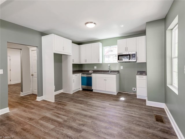 kitchen featuring white cabinets, dark hardwood / wood-style floors, sink, and dishwashing machine