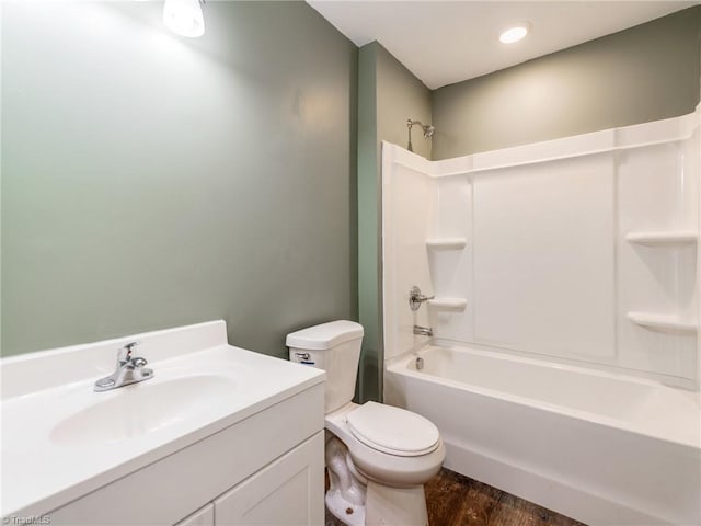 full bathroom with hardwood / wood-style floors, vanity,  shower combination, and toilet