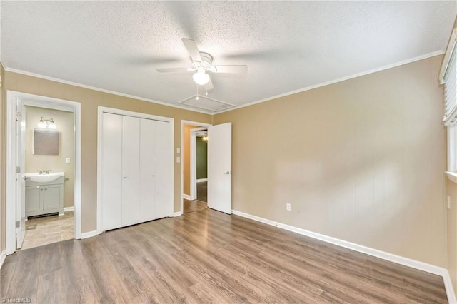 225 E Greencrest Dr, Millers Creek, NC 28651 - unfurnished bedroom with wood finished floors, a closet, baseboards, a textured ceiling, and ensuite bathroom