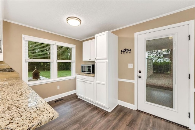 225 E Greencrest Dr, Millers Creek, NC 28651 - kitchen with dark wood-style flooring, baseboards, crown molding, white cabinetry, and stainless steel microwave
