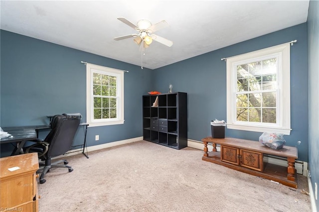 office space featuring baseboards, ceiling fan, and carpet