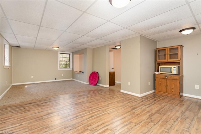 interior space with baseboards, light wood-type flooring, and a drop ceiling