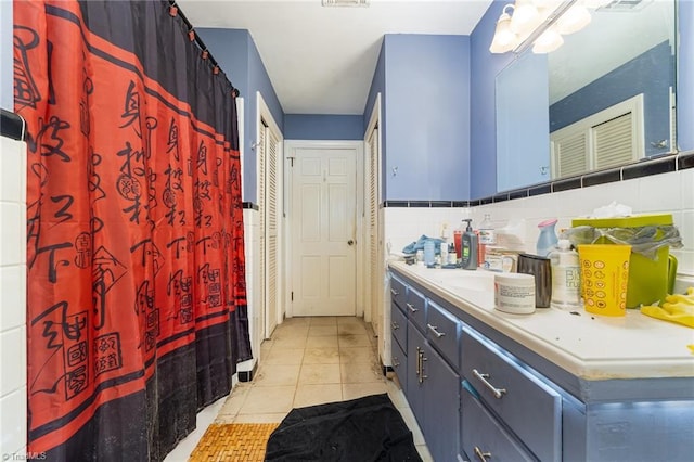 full bath featuring tile walls, backsplash, tile patterned flooring, and vanity