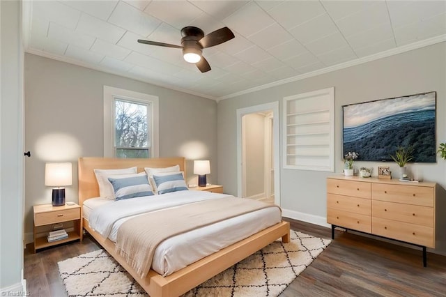 bedroom with wood finished floors, ceiling fan, ornamental molding, and baseboards