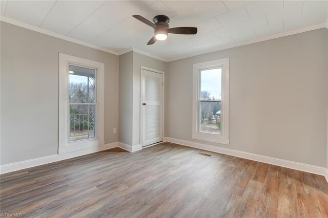 unfurnished bedroom with baseboards, visible vents, wood finished floors, and ornamental molding