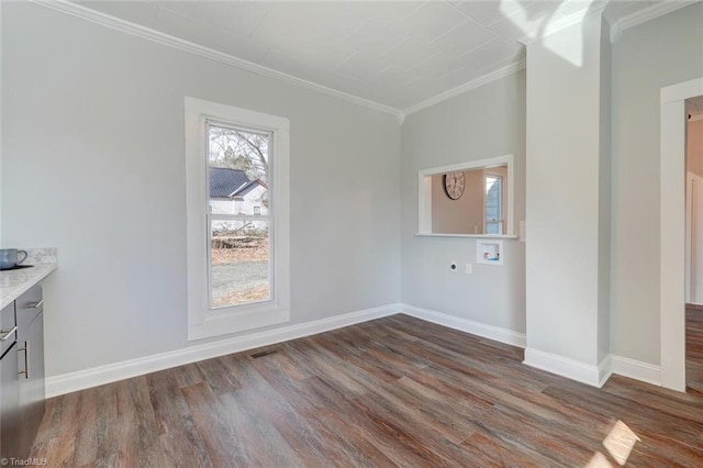 empty room with ornamental molding, baseboards, and dark wood-type flooring