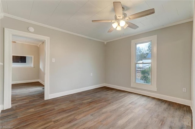 empty room featuring baseboards, wood finished floors, ceiling fan, and crown molding