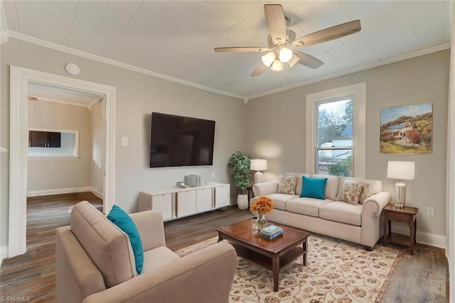living area with wood finished floors, a ceiling fan, ornamental molding, and baseboards