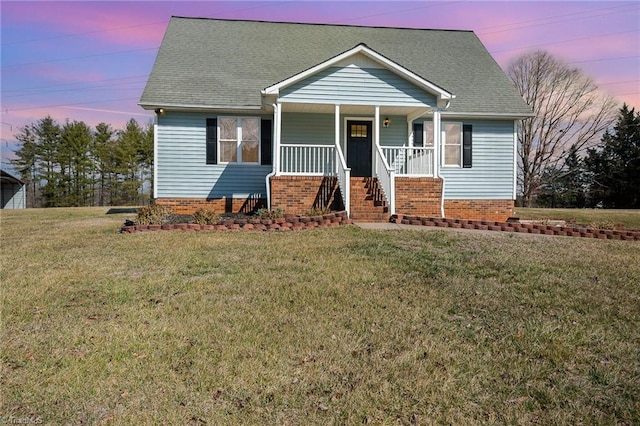 view of front of home featuring a shingled roof, a porch, and a front yard