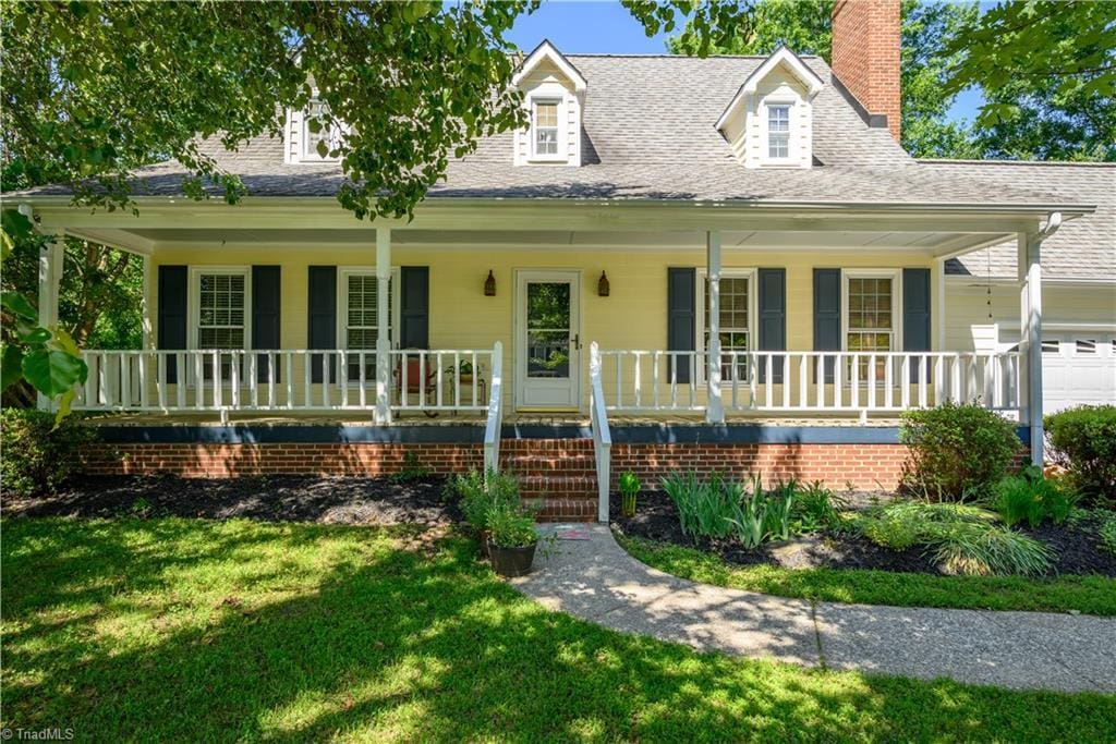 1632 Round Hill Cir, Kernersville, NC 27284 - view of front of house featuring a porch, a chimney, a front lawn, and a shingled roof