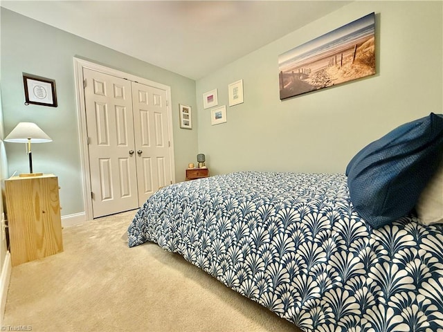 carpeted bedroom featuring a closet and baseboards