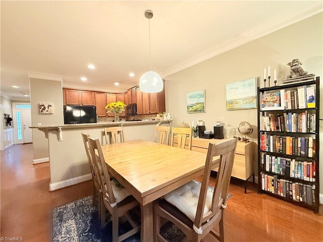 dining space featuring crown molding, recessed lighting, wood finished floors, and baseboards