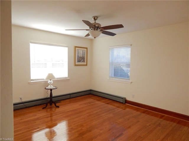 empty room with baseboard heating, ceiling fan, and hardwood / wood-style flooring