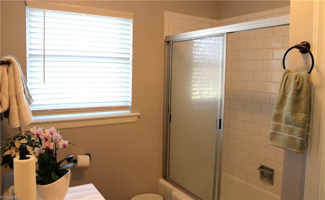 bathroom featuring a wealth of natural light and combined bath / shower with glass door