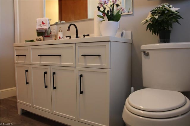 bathroom with hardwood / wood-style floors, vanity, and toilet