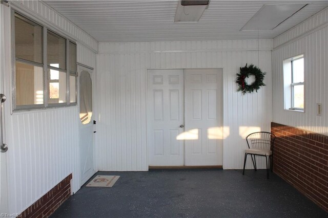 unfurnished room featuring brick wall