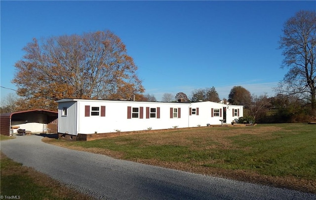 view of front facade with a carport and a front yard