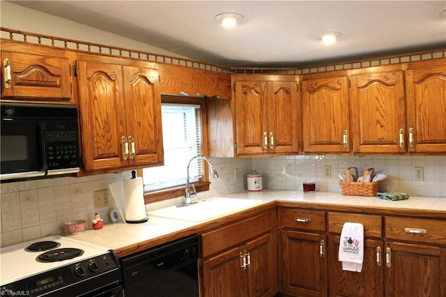 kitchen with black appliances, tasteful backsplash, sink, and tile countertops