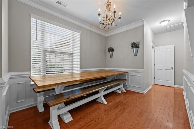 183 Kentland Ridge Dr, Kernersville, NC 27284 - dining space featuring a chandelier, hardwood / wood-style flooring, a decorative wall, a wainscoted wall, and ornamental molding