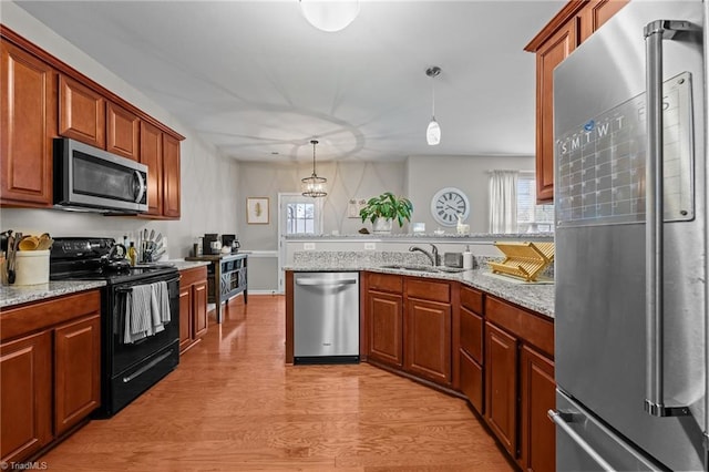 183 Kentland Ridge Dr, Kernersville, NC 27284 - kitchen with stainless steel appliances, a sink, a peninsula, light wood-type flooring, and healthy amount of natural light