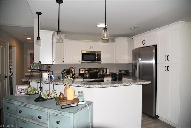 kitchen with visible vents, white cabinetry, dark stone counters, appliances with stainless steel finishes, and a peninsula