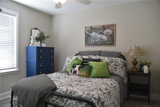 bedroom featuring ceiling fan, baseboards, and wood finished floors