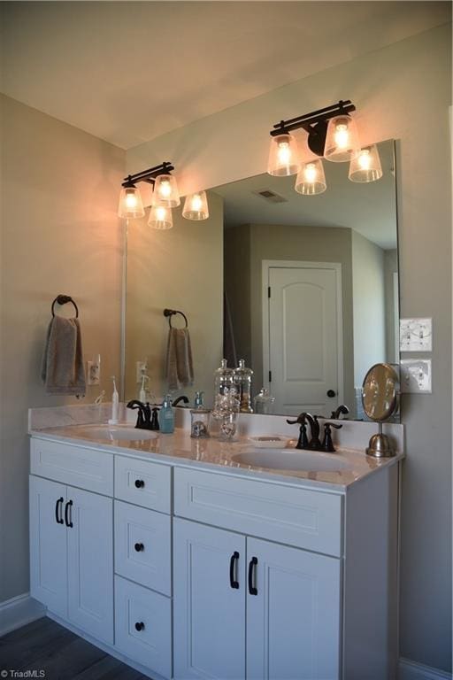 bathroom featuring double vanity, visible vents, and a sink