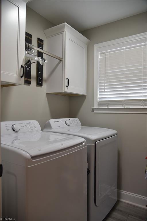 washroom with wood finished floors, cabinet space, independent washer and dryer, and baseboards