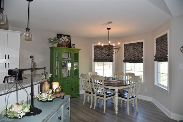 dining area with baseboards, dark wood-style floors, visible vents, and a chandelier