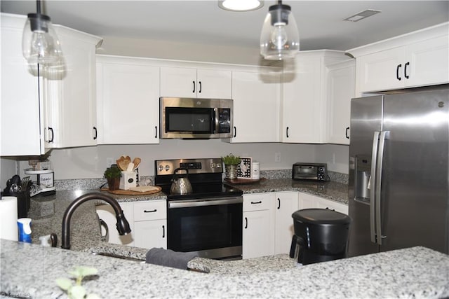 kitchen featuring white cabinets, stainless steel appliances, and light stone countertops