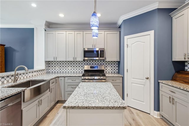 5360 Graycliff Ln, Clemmons, NC 27012 - kitchen featuring appliances with stainless steel finishes, light wood finished floors, gray cabinets, crown molding, and a kitchen island