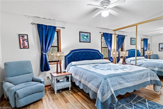 bedroom with a ceiling fan, wood finished floors, a closet, and a textured ceiling