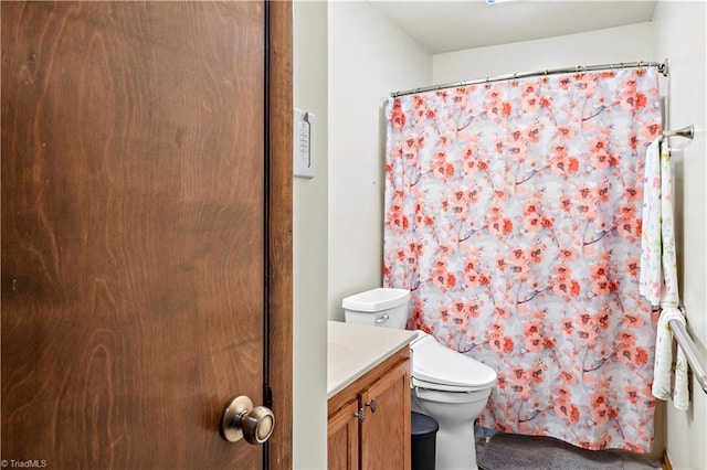 bathroom featuring a shower with curtain, toilet, and vanity