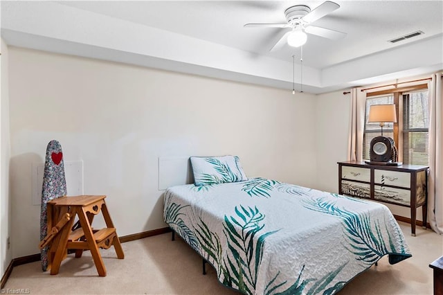 bedroom featuring visible vents, light colored carpet, a ceiling fan, and baseboards