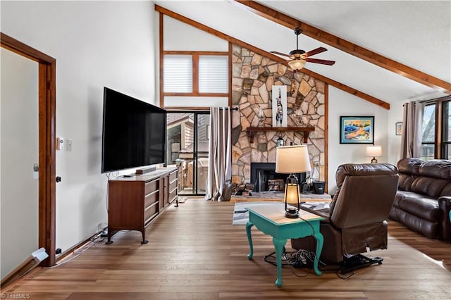 living room with beam ceiling, a ceiling fan, wood finished floors, a fireplace, and baseboards