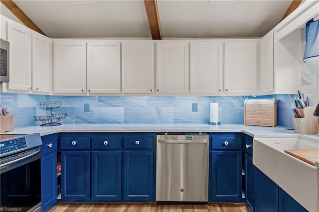 kitchen featuring light countertops, blue cabinetry, light wood finished floors, and appliances with stainless steel finishes