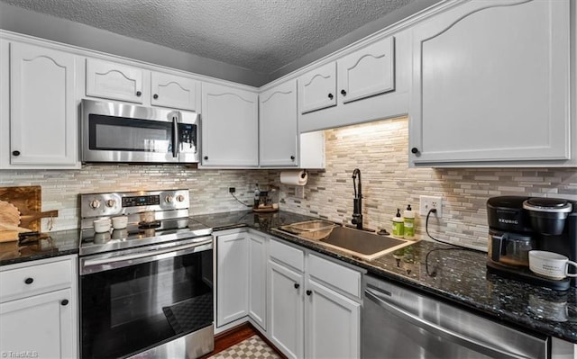 kitchen featuring a sink, appliances with stainless steel finishes, and white cabinets