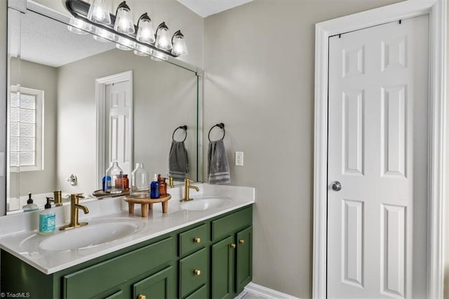 full bathroom with double vanity, baseboards, and a sink