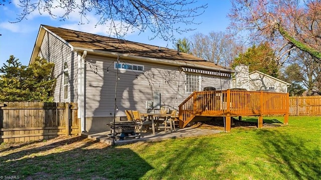 rear view of house featuring a deck, a lawn, a patio, and a fenced backyard