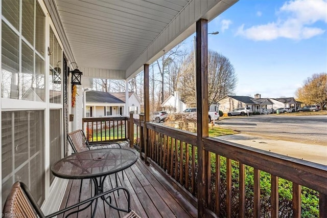 wooden terrace with covered porch and a residential view