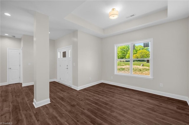 unfurnished room with dark wood-style floors, a raised ceiling, baseboards, visible vents, and recessed lighting