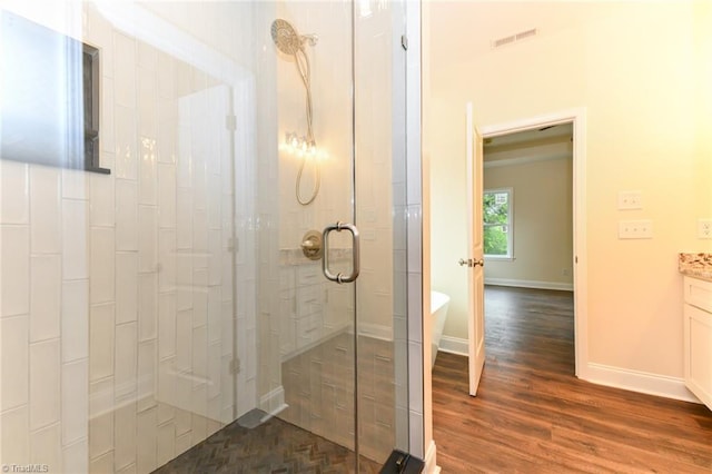 full bath with a freestanding bath, wood finished floors, vanity, baseboards, and a stall shower