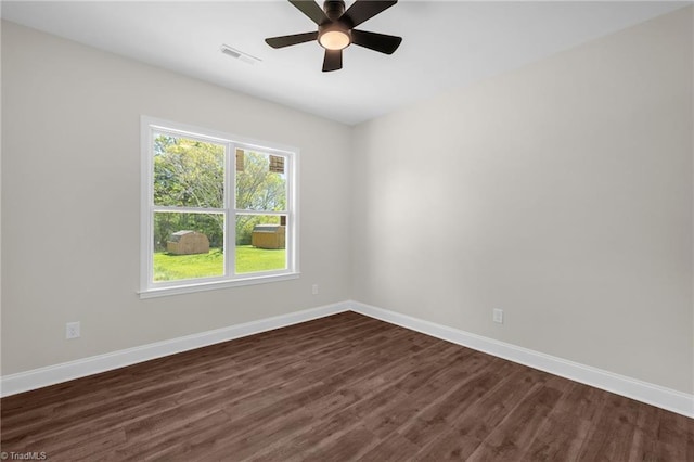 unfurnished room featuring dark wood finished floors, baseboards, a ceiling fan, and visible vents