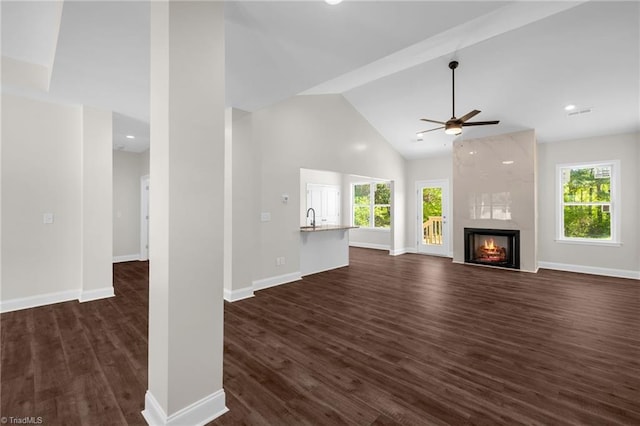 unfurnished living room with plenty of natural light, a sink, dark wood-type flooring, and ceiling fan