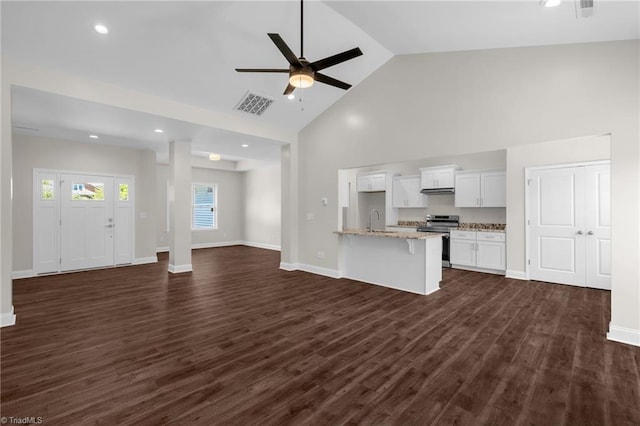 unfurnished living room with visible vents, a ceiling fan, a sink, baseboards, and high vaulted ceiling
