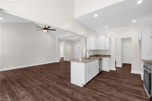 kitchen with white cabinets, a peninsula, stainless steel appliances, a sink, and a ceiling fan