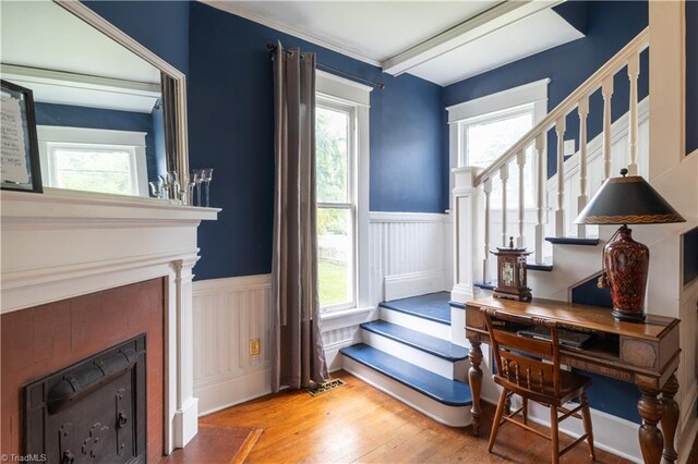 entrance foyer featuring plenty of natural light, light hardwood / wood-style floors, and beam ceiling