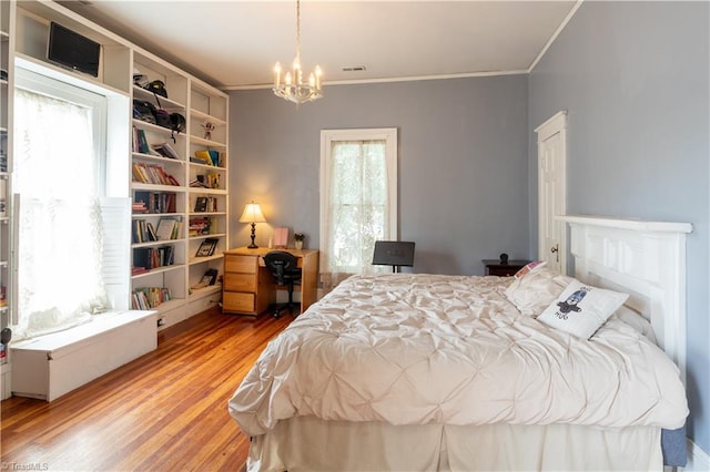 bedroom with light hardwood / wood-style floors, crown molding, and a chandelier