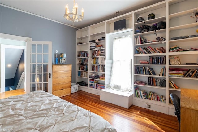 bedroom with wood-type flooring and a chandelier